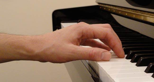 Photo d'une main bien positionnée sur le piano